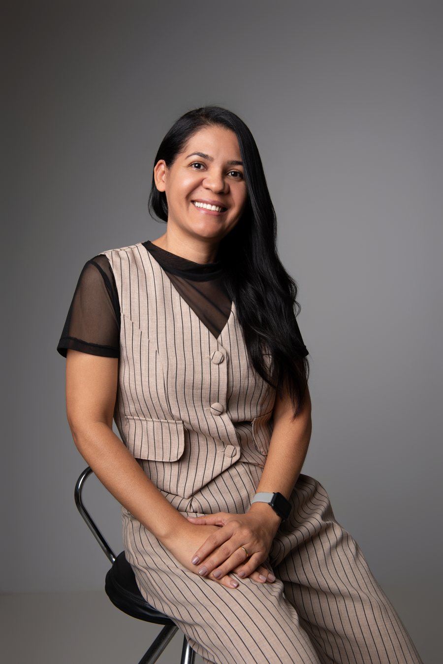 Dra. Railde Bontadine, nutricionista integrativa, sentada em uma poltrona segurando uma xícara.